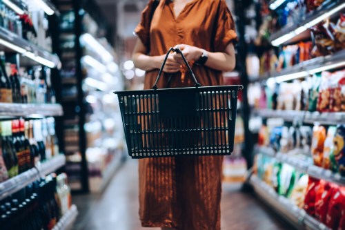 Woman shopping in a grocery store with a basket