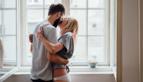 Two people passionately kiss in this story art for a round up of standing sex positions.